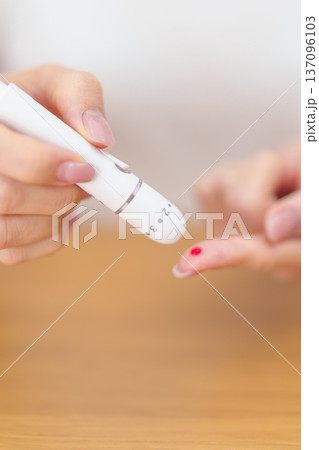 Hand using lancet pen on finger with Blood drop glucose testing or Diabetes checking by digital blood glucose meter. blood sugar level, Diabetes Day, Glycemia, Hypoglycemia, Hyperglycemia and insulin Hand using lancet pen on finger with Blood drop glucose testing or Diabetes checking by digital blood glucose meter. blood sugar level, Diabetes Day, Glycemia, Hypoglycemia, Hyperglycemia and insulin 137096103