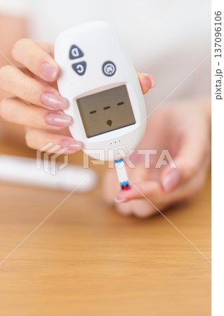 Hand checking Diabetes or Blood glucose self testing by digital blood glucose meter with lancet pen. high blood sugar level, World Diabetes Day, Glycemia, Hypoglycemia, Hyperglycemia and insulin Hand checking Diabetes or Blood glucose self testing by digital blood glucose meter with lancet pen. high blood sugar level, World Diabetes Day, Glycemia, Hypoglycemia, Hyperglycemia and insulin 137096106