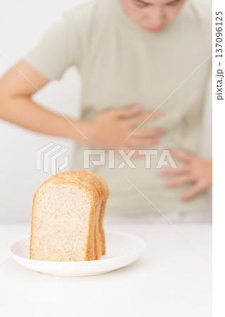 Gluten intolerance, Gluten free and celiac disease or Wheat allergy. woman with wheat bread and having abdominal pain after eat gluten. stomach ache, Nausea, Bloating, Gas, Diarrhea and Skin rash Gluten intolerance, Gluten free and celiac disease or Wheat allergy. woman with wheat bread and having abdominal pain after eat gluten. stomach ache, Nausea, Bloating, Gas, Diarrhea and Skin rash 137096125