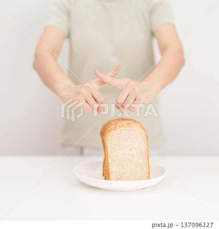 Unhappy woman showing Rejecting gesture and refusing to eat bread. concept of gluten intolerance, gluten sensitivity, carb loading concerns, or a disliking for unhealthy dietary habits Unhappy woman showing Rejecting gesture and refusing to eat bread. concept of gluten intolerance, gluten sensitivity, carb loading concerns, or a disliking for unhealthy dietary habits 137096127