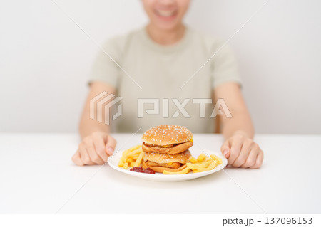 happy woman eating Juicy beef burger with melted cheddar cheese, potato chips. Unhealthy, High calorie, Fast food craving, Obesity, diet, weight loss, junk food and lifestyle happy woman eating Juicy beef burger with melted cheddar cheese, potato chips. Unhealthy, High calorie, Fast food craving, Obesity, diet, weight loss, junk food and lifestyle 137096153