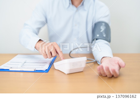 Man checking Blood pressure by Blood pressure monitor with Cuff. Systolic, SYS, Diastolic, DIA, Pulse, Hypertension, Hypotension, Heart rate, Cardiovascular Disease and May World hypertension day Man checking Blood pressure by Blood pressure monitor with Cuff. Systolic, SYS, Diastolic, DIA, Pulse, Hypertension, Hypotension, Heart rate, Cardiovascular Disease and May World hypertension day 137096162