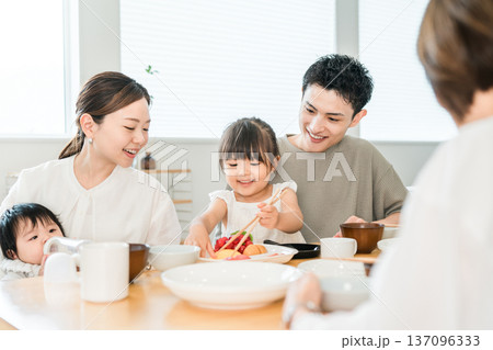 食卓でおままごとをしながらお箸の練習をする女の子と家族,ファミリー 137096333