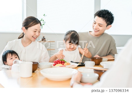 食卓でおままごとをしながらお箸の練習をする女の子と家族,ファミリー 137096334