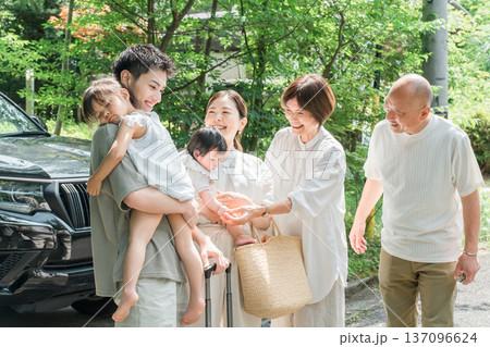 実家に帰省した孫娘を抱っこする母親と父親と出迎える両親(里帰り,三世代家族) 実家に帰省した孫娘を抱っこする母親と父親と出迎える両親(里帰り,三世代家族) 137096624