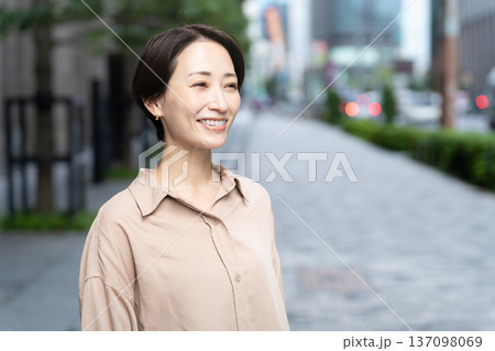 ビル街を散策する女性 137098069
