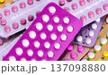 Collection of hormonal birth control pills in different colors and packaging. 137098880