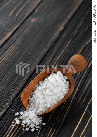 sea salt in wooden scoop on dark wooden table 137099040
