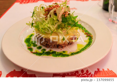 Duck confit with mashed potatoes and salad on a table in restaurant 137099855