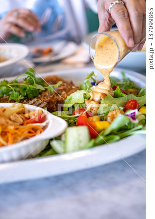 Top view of Pour the salad dressing over the vegetables, focus selective Top view of Pour the salad dressing over the vegetables, focus selective 137099865