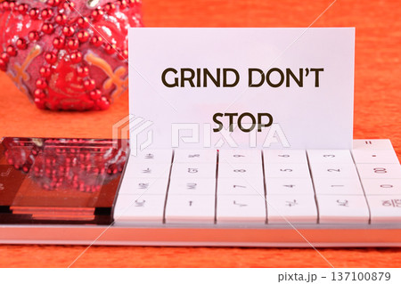 A white card proclaiming GRIND DONT STOP stands proudly in a calculator, a vivid symbol of unyielding dedication in a bright setting A white card proclaiming GRIND DONT STOP stands proudly in a calculator, a vivid symbol of unyielding dedication in a bright setting 137100879