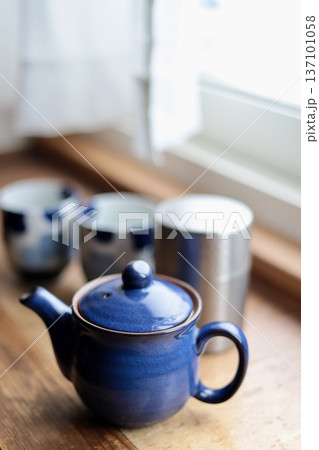 窓辺に置いた日本茶のセット 青い急須と茶筒と湯呑み茶碗 窓辺に置いた日本茶のセット 青い急須と茶筒と湯呑み茶碗 137101058