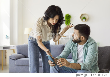 Quarrel of couple over smartphone using at home, wife shouting scolding husband Quarrel of couple over smartphone using at home, wife shouting scolding husband 137101176