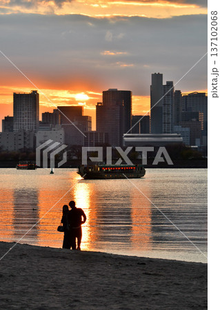 お台場海浜公園お台場ビーチにて、夕焼けを眺めるカップル 137102068