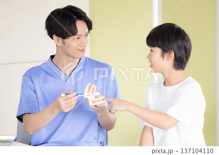 歯医者　歯磨き指導を受ける男の子と医師 137104110