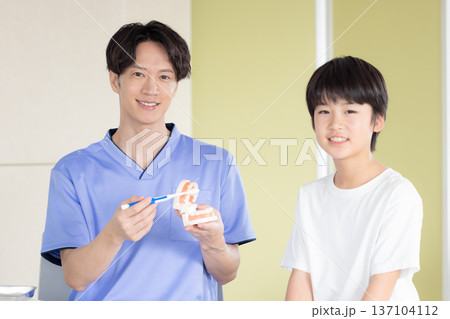 歯医者　歯磨き指導を受ける男の子と医師 137104112