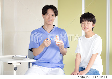 歯医者 歯磨き指導を受ける男の子と医師 歯医者 歯磨き指導を受ける男の子と医師 137104116