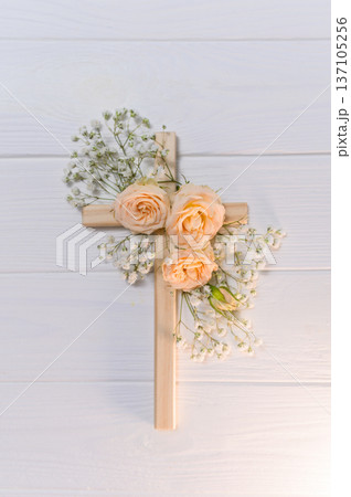Vertical Wooden cross decorated with gypsophila flowers on a white background for easter and good friday celebrations copyspace 137105256