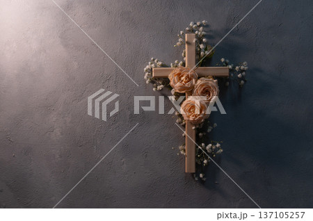 Wooden christian cross with pink roses and gypsophila flowers on a dark shadow wall representing faith and easter symbolizing faith, resurrection copyspace Wooden christian cross with pink roses and gypsophila flowers on a dark shadow wall representing faith and easter symbolizing faith, resurrection copyspace 137105257