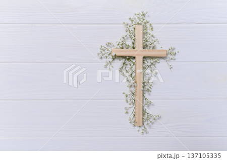 Wooden cross decorated with gypsophila flowers on a white background for easter and good friday celebrations copyspace 137105335