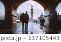 over-the-shoulder photo of two people walking past big ben in london, taken from an arched doorway, with motion blur 137105443