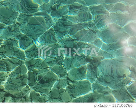 Clear shallow turquoise sea water over rocky seabed texture background for coastal wallpaper and marine design and pattern use Clear shallow turquoise sea water over rocky seabed texture background for coastal wallpaper and marine design and pattern use 137106766
