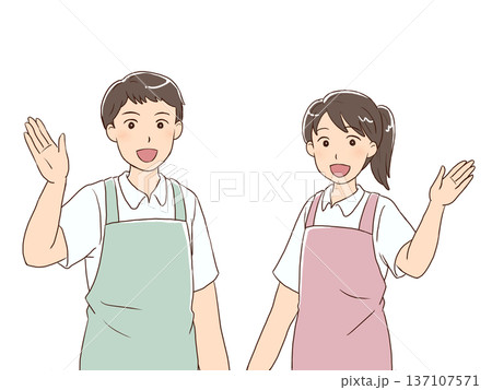 笑顔で案内をする爽やかなエプロン姿の男女 137107571