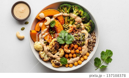 Colorful roasted pumpkin and broccoli quinoa bowl with chickpeas and creamy tahini sauce for healthy lunch and banner design Colorful roasted pumpkin and broccoli quinoa bowl with chickpeas and creamy tahini sauce for healthy lunch and banner design 137108378