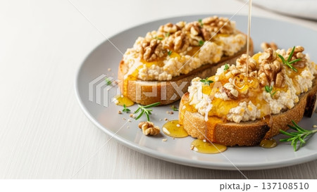 Sourdough toast topped with ricotta walnuts and flowing honey pour for brunch menu background and food styling 137108510