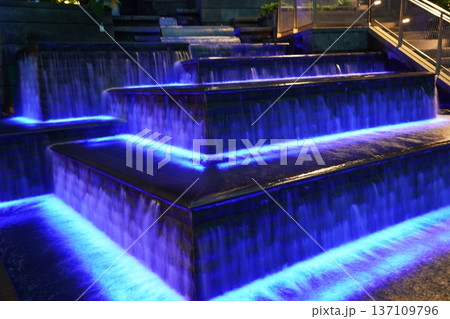 Mesmerizing Blue Light Water Cascade in Modern Urban Setting Mesmerizing Blue Light Water Cascade in Modern Urban Setting 137109796