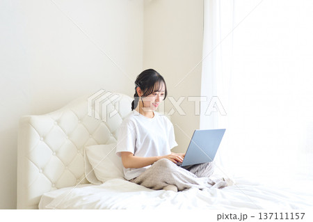 ベッドでパソコン作業をする女性 ベッドでパソコン作業をする女性 137111157