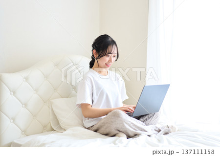 ベッドでパソコン作業をする女性 ベッドでパソコン作業をする女性 137111158