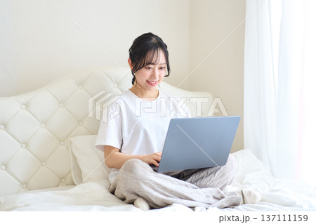 ベッドでパソコン作業をする女性 ベッドでパソコン作業をする女性 137111159