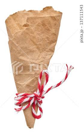 A rolled up cone of crumpled craft paper tied with a red and white string and a bow A rolled up cone of crumpled craft paper tied with a red and white string and a bow 137111543