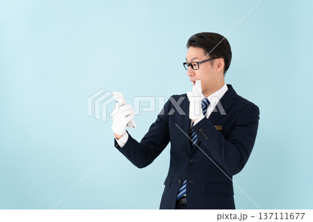 白手袋で計算機を持つ男性　驚く 137111677