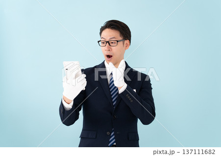 白手袋で計算機を持つ男性 驚く 白手袋で計算機を持つ男性 驚く 137111682