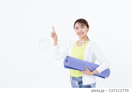 ヨガマットを持つ若い女性 ヨガマットを持つ若い女性 137111770