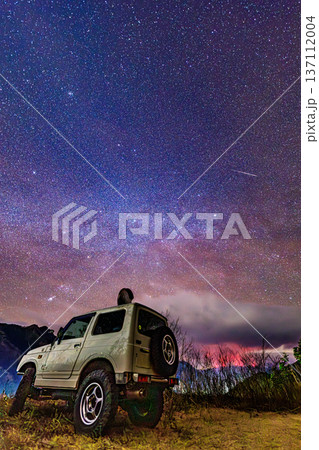 流星と天の川の下に佇むオフロード車 星空と大地の幻想的な夜景 137112004