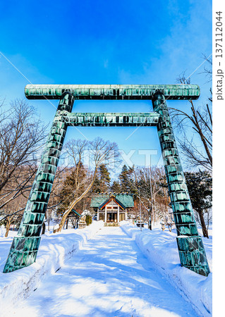 青空と雪景色に映える小清水神社の鳥居と社殿 北海道の冬風景 137112044
