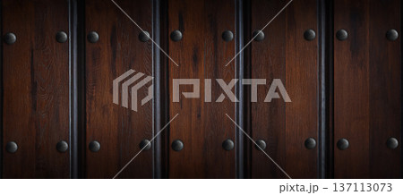 Dark wooden wall panels with metal rivets arranged in a vertical pattern, showcasing rich textures and natural grain, ideal for interior design and architectural applications 137113073