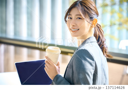 笑顔で振り向くスーツ姿の日本人女性撮影協力:スカパー東京メディアセンター 137114626