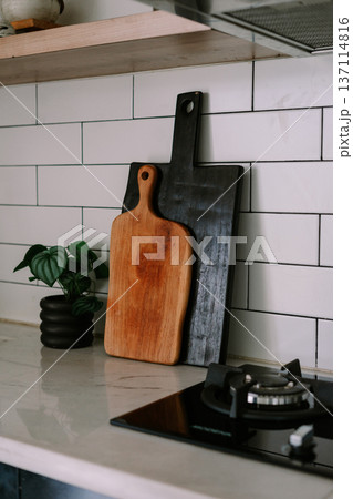 Modern Kitchen Countertop with Stylish Wooden Cutting Boards and Plant Modern Kitchen Countertop with Stylish Wooden Cutting Boards and Plant 137114816
