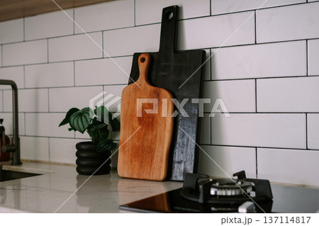 Modern Kitchen Counter with Stylish Cutting Boards and Plant 137114817