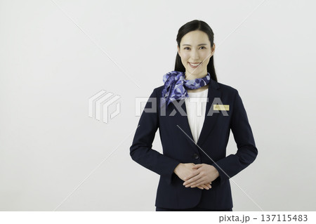 白背景の紺のスーツにリボン、ネームタグをつけた笑顔の日本人女性 コンシェルジェ 白背景の紺のスーツにリボン、ネームタグをつけた笑顔の日本人女性 コンシェルジェ 137115483
