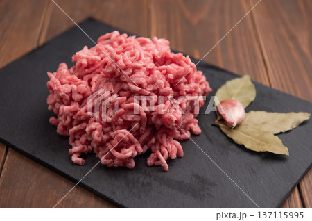 Fresh minced pork on black plate and wooden background. 137115995