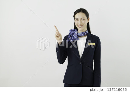 白背景の紺のスーツにリボン、ネームタグをつけて1番のポーズをする笑顔の日本人女性 コンシェルジェ 白背景の紺のスーツにリボン、ネームタグをつけて1番のポーズをする笑顔の日本人女性 コンシェルジェ 137116086