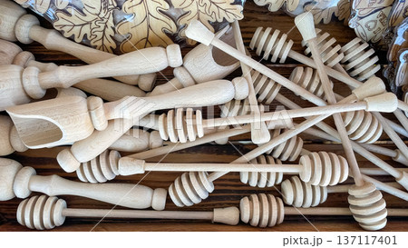 A pile of handmade wooden honey dippers and kitchen scoops at a local craft market or workshop. 137117401