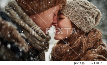 Couple sharing a kiss in a snowy setting during winter while enjoying the moment together Couple sharing a kiss in a snowy setting during winter while enjoying the moment together 137118146