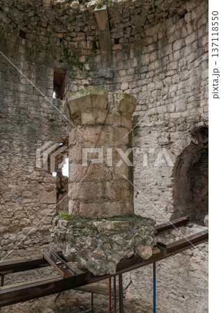 Stone pillar and arched window inside Anacopia fortress tower in Abkhazia with textured masonry walls, natural light, Historic architectural interior suitable for tourism marketing, heritage education 137118550