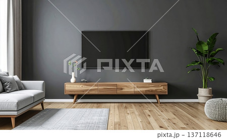 Modern minimalist living room interior with a large flat screen TV mounted on a dark gray wall, wooden TV stand, cozy sofa, potted plant, and natural light 137118646